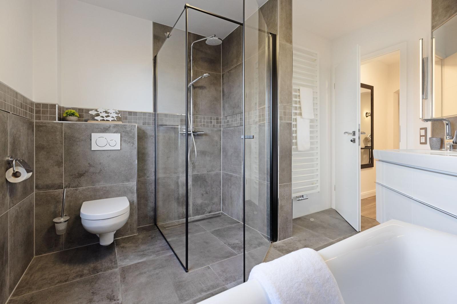 Badezimmer mit Dusche, Toilette und Badewanne.