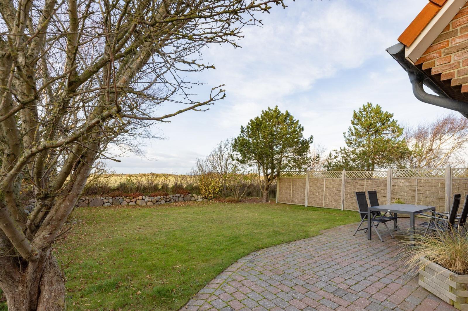 Hinterhof mit Rasenfläche, Pflasterweg und Gartenmöbeln. Hinterhof mit Rasenfläche, Pflasterweg und Gartenmöbeln.