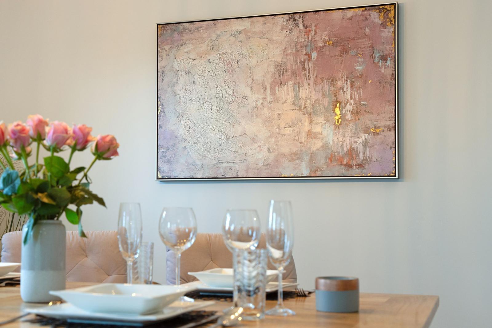 Esstisch mit Gläsern und Blumen vor Wandbild