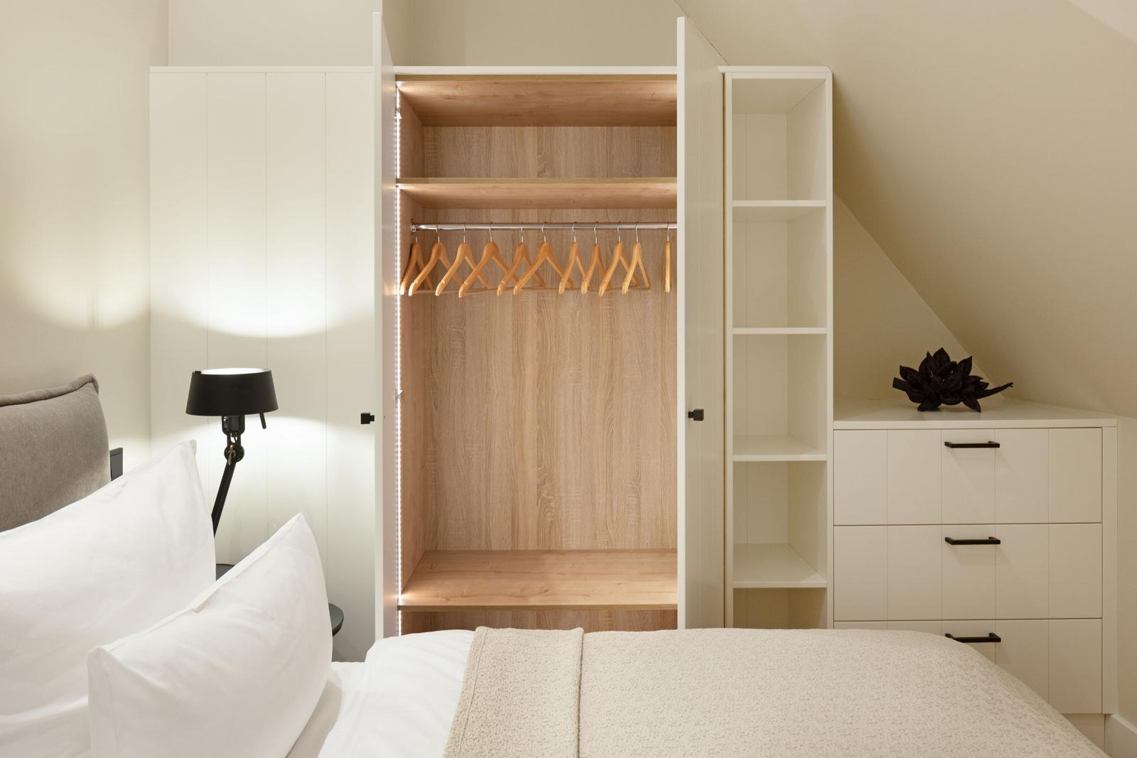 Schlafzimmer mit Kleiderschrank, Bett und Nachttisch.