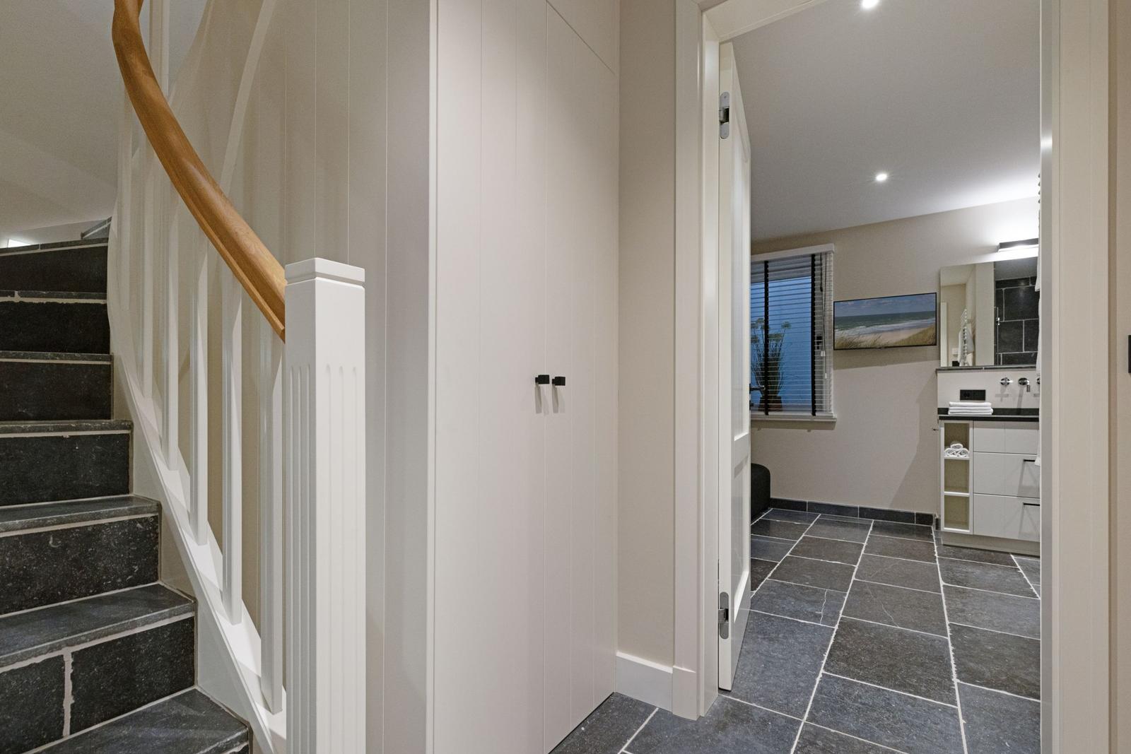 Haus mit Flur, Treppe und angrenzender Badewanne.