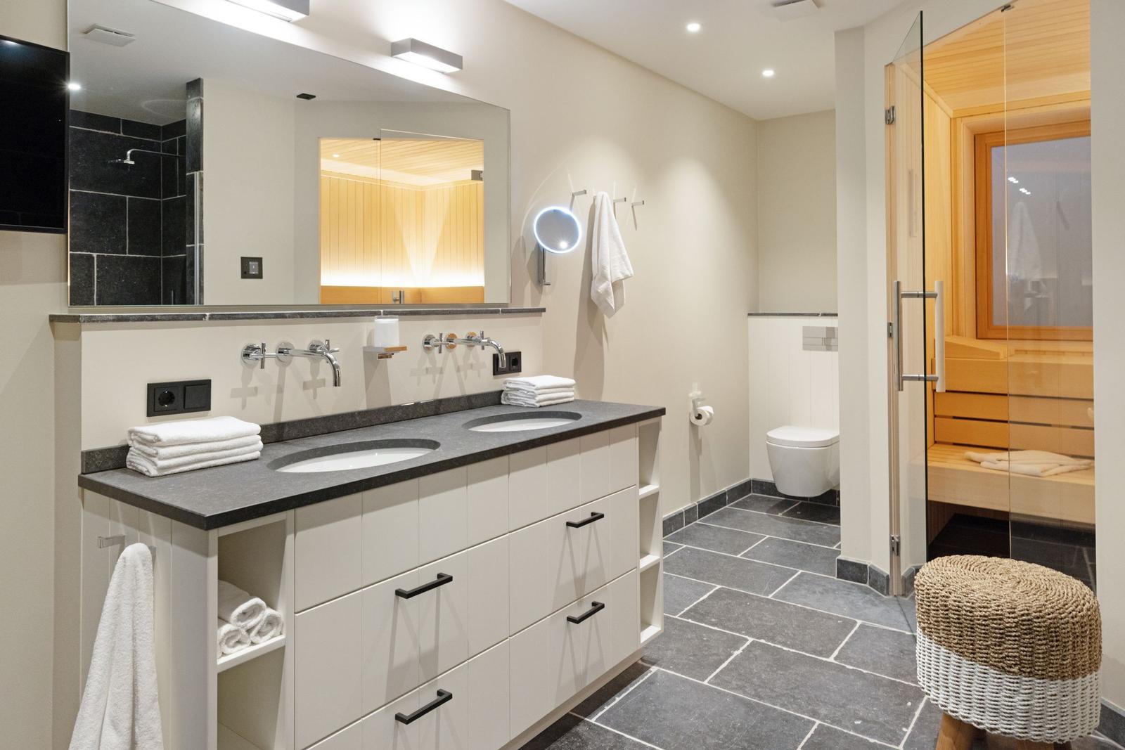 Bad mit Doppelwaschbecken, Sauna und moderner Einrichtung.