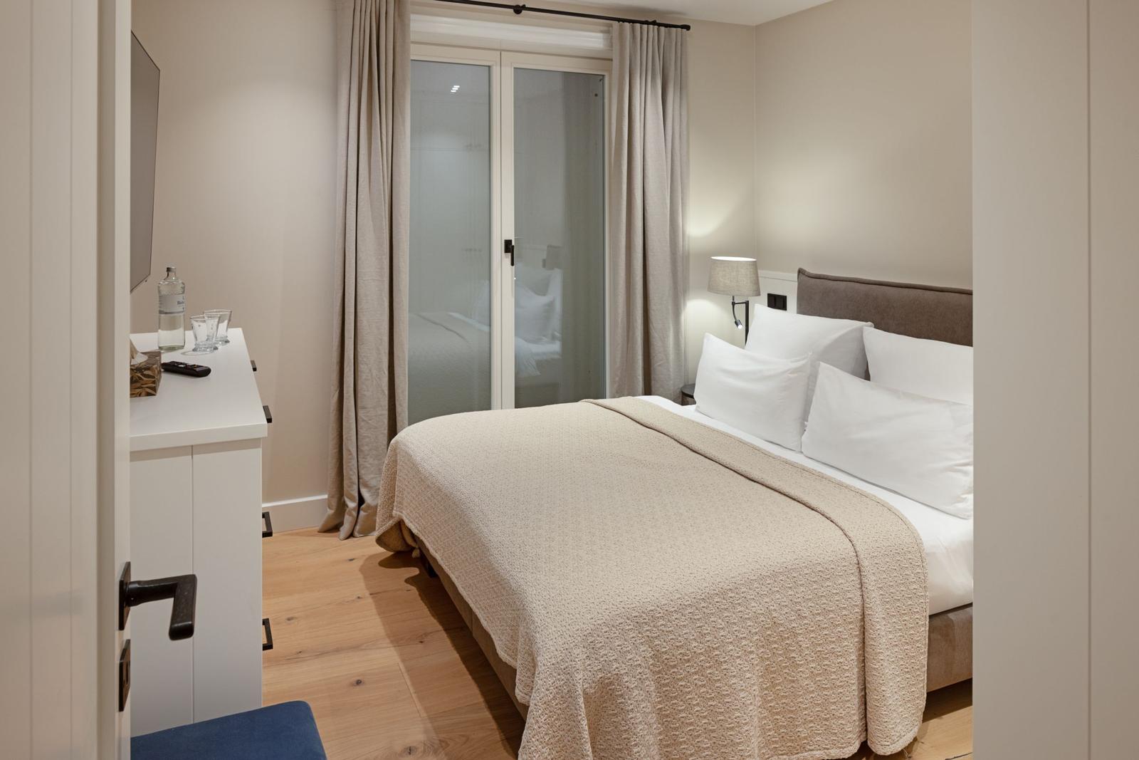 Schlafzimmer mit Bett, Schrank und Fenster