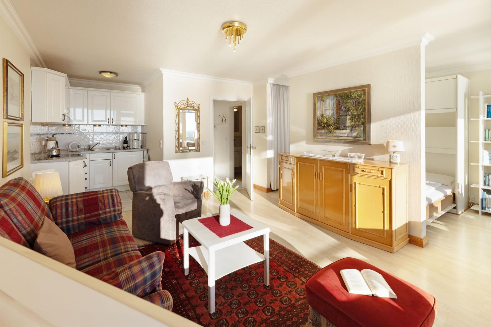 Wohnung mit Küche, Sitzbereich und Schlafbereich. Einrichtung mit Sofa, Couchtisch und Schrank.