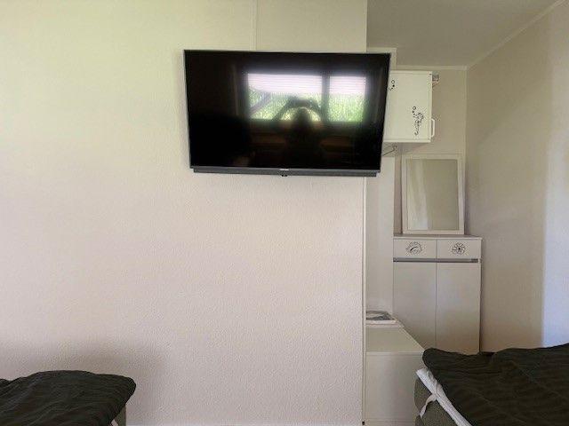 Schlafzimmer mit Wandfernseher und Kleiderschrank