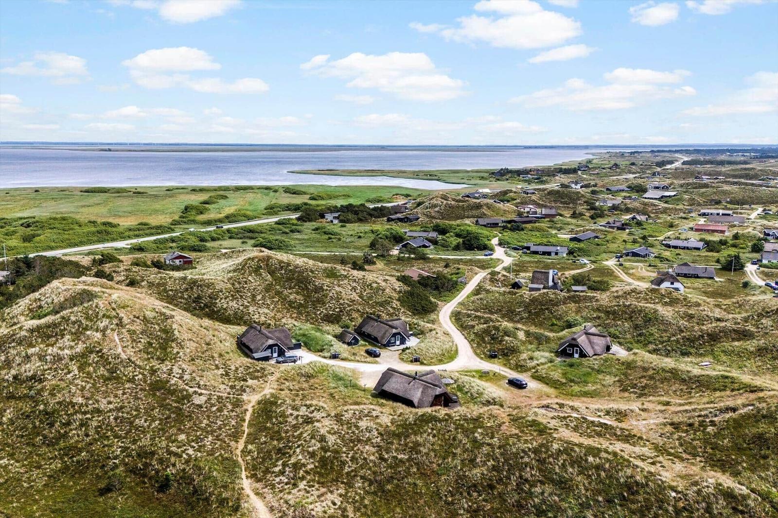 Dorf auf Dünen mit Häusern und Blick auf Wasser