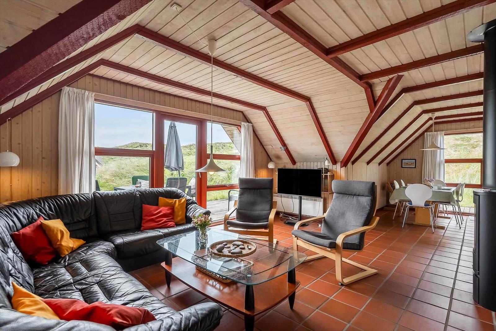 Wohn- und Essbereich mit Sofa, Sesseln und großem Fensterblick.