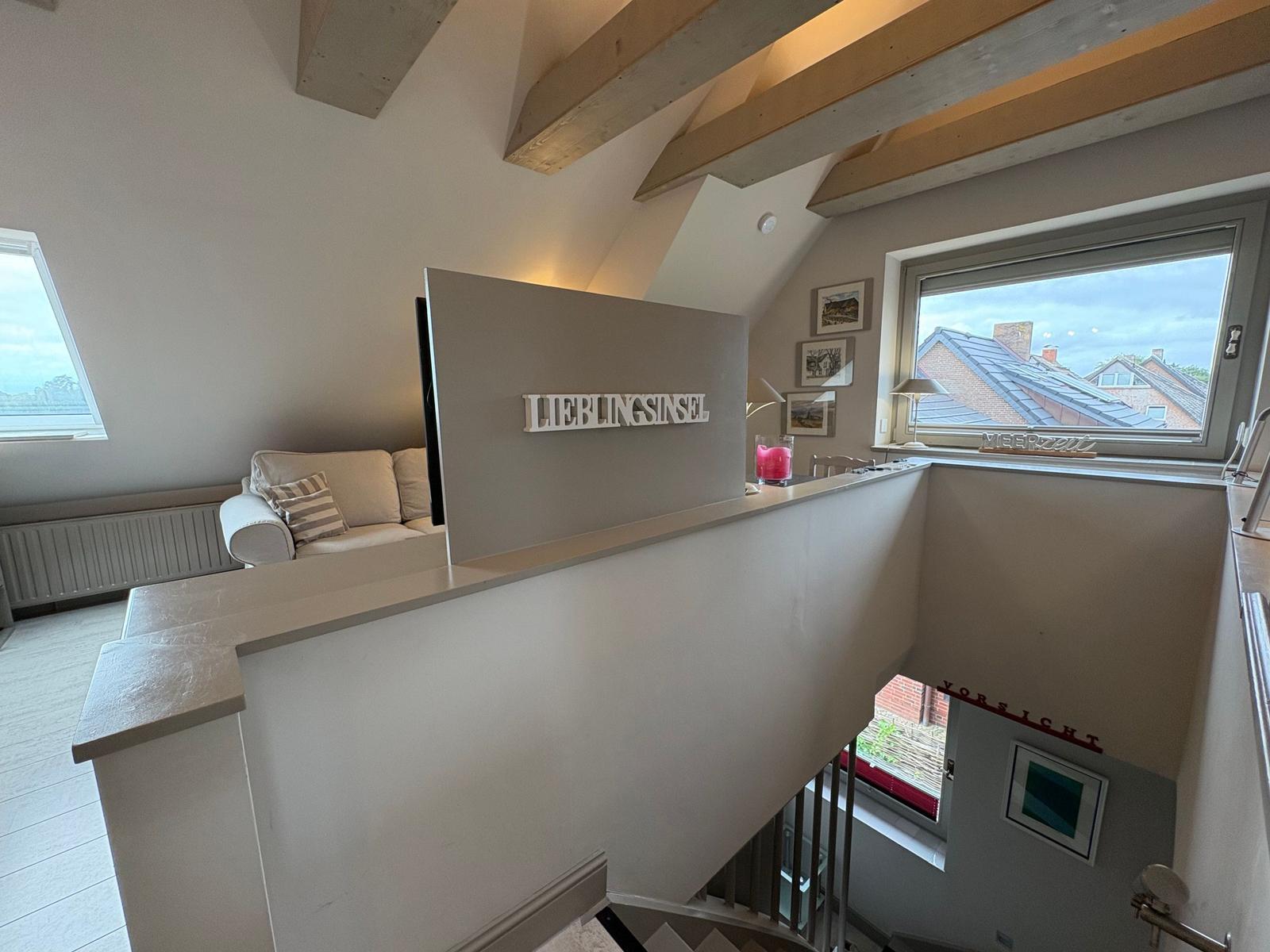 Living area with sofa, view of roof and window overlooking rooftops.