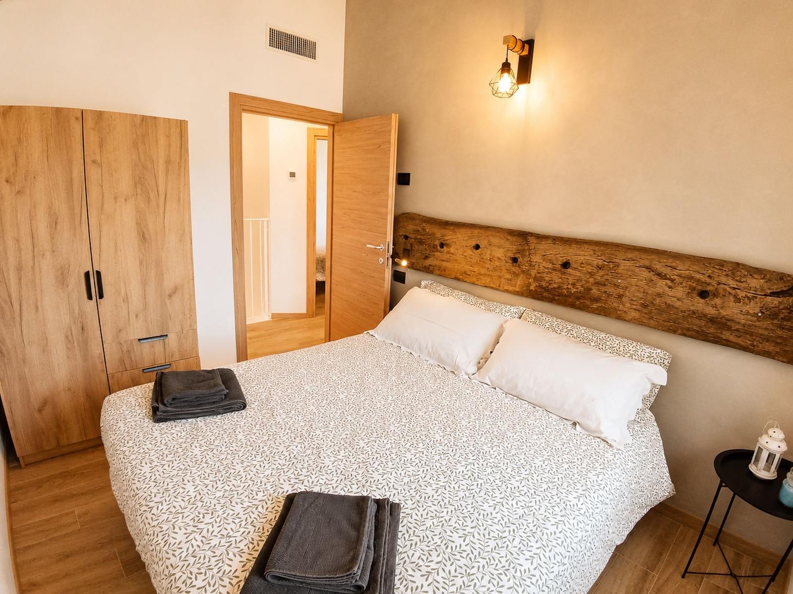 Schlafzimmer mit Naturholz und Kleiderschrank