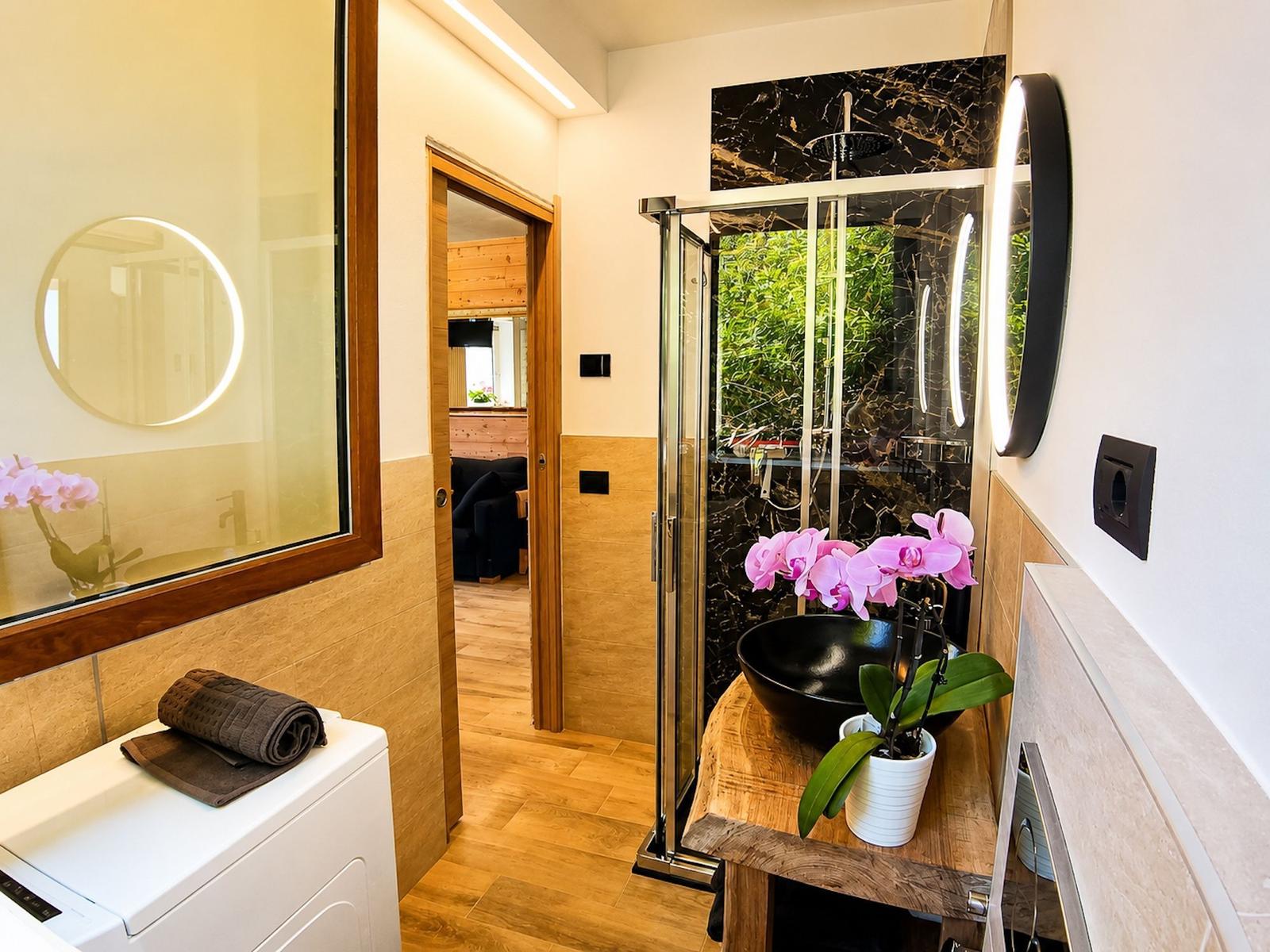 gut ausgestattetes Badezimmer mit Dusche und Waschmaschine