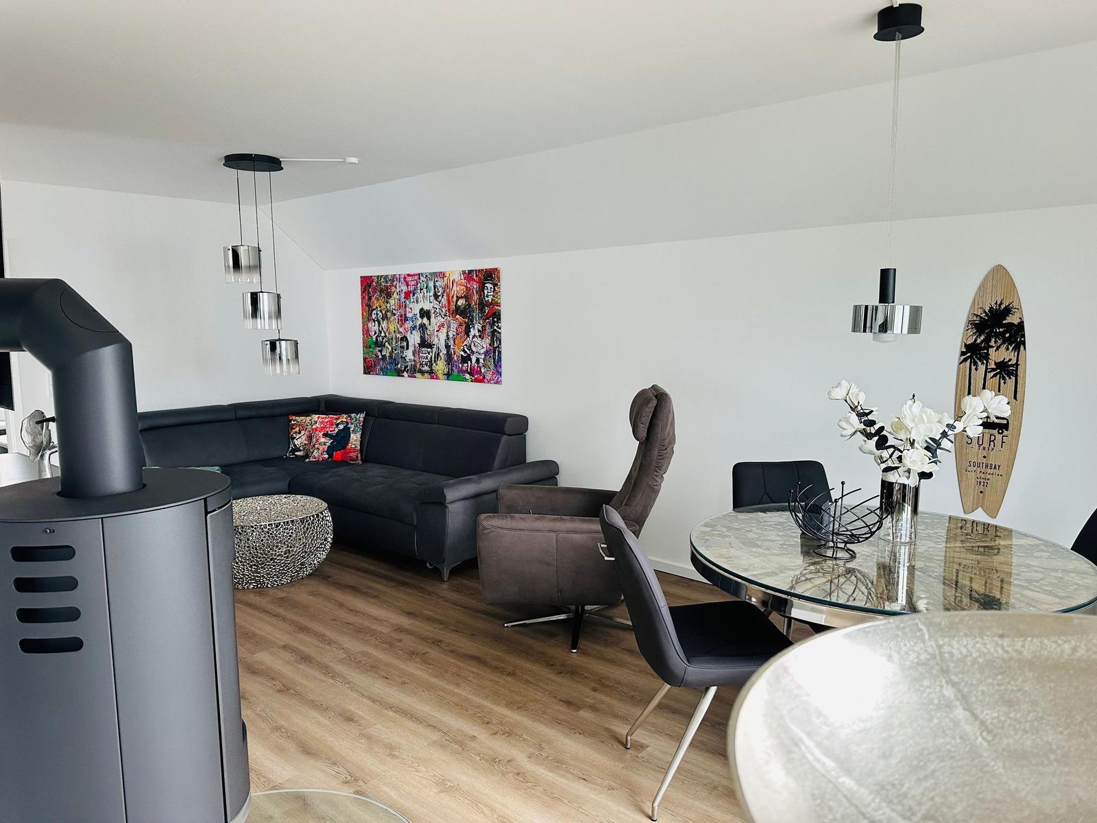Wohn- und Essbereich mit Sofa, Esstisch und Wandkunst.
