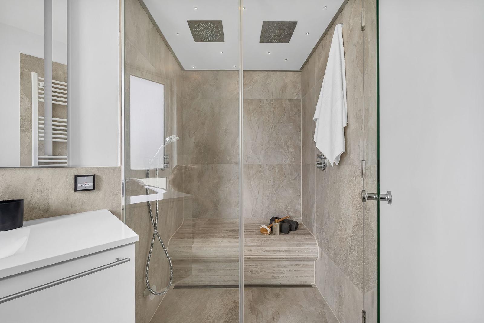 Dusche mit Glaswand, Duschbrause und Handtuch