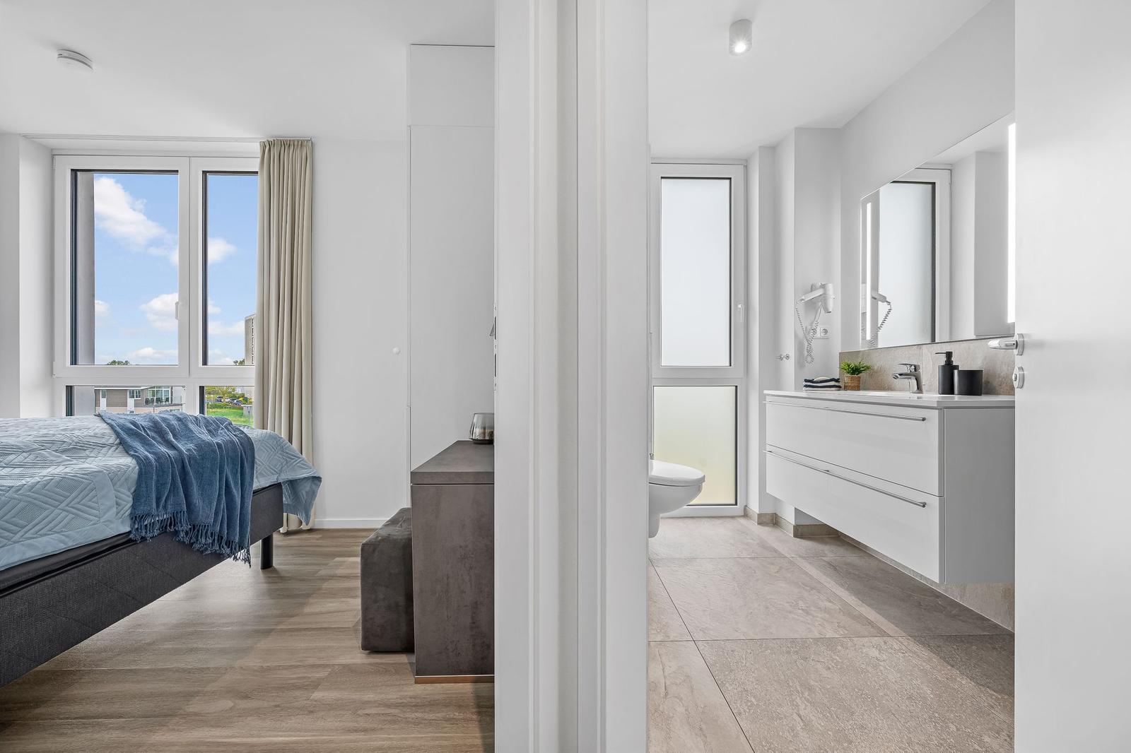 Schlafzimmer mit Blick auf den Himmel. Neben dem Bad mit Waschtisch und Toilette.