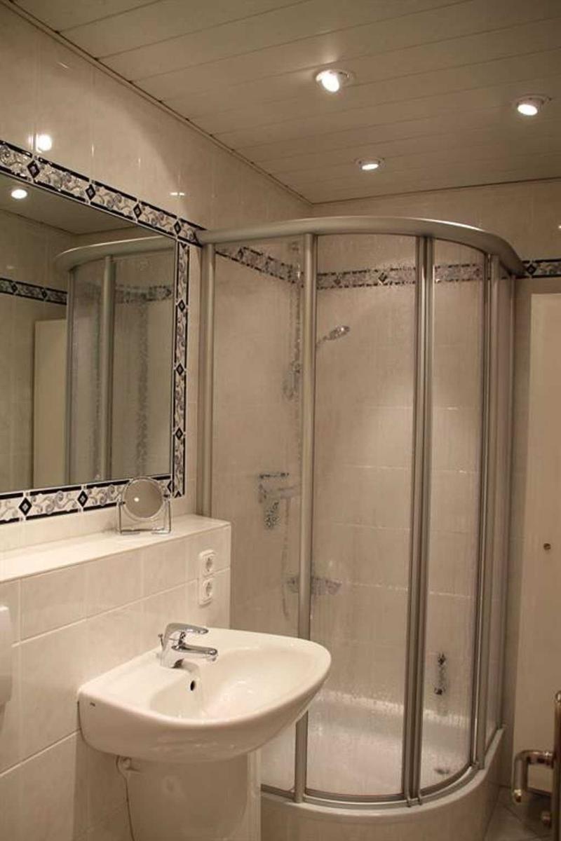 Bathroom with shower, sink, and mirror with trim.
