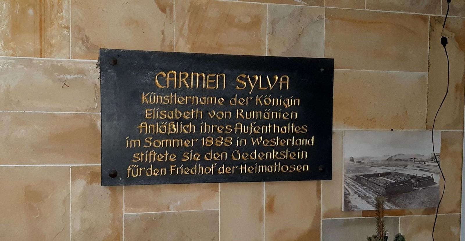 Memorial plaque for Carmen Sylva on the wall, next to a black-and-white photograph.