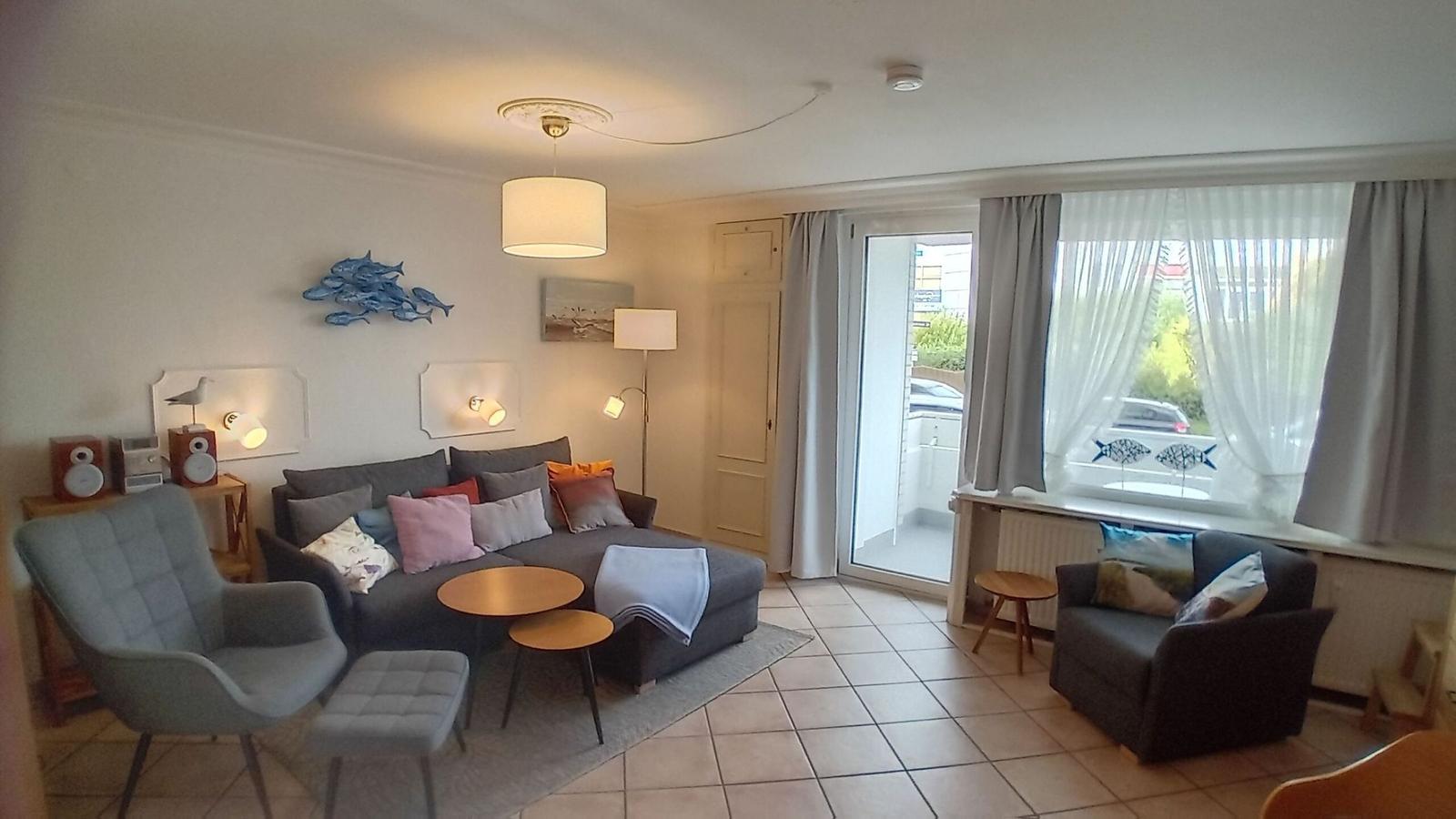 Wohnzimmer mit Couchecke und Ausgang zum Balkon