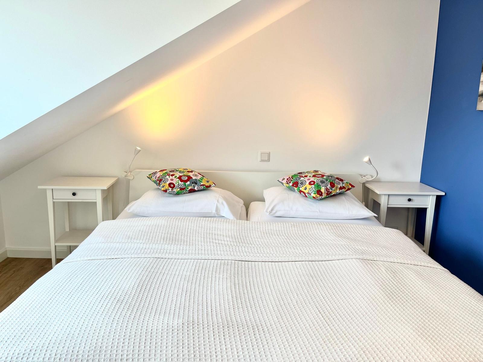 Helles Schlafzimmer mit Doppelbett und Nachtischen