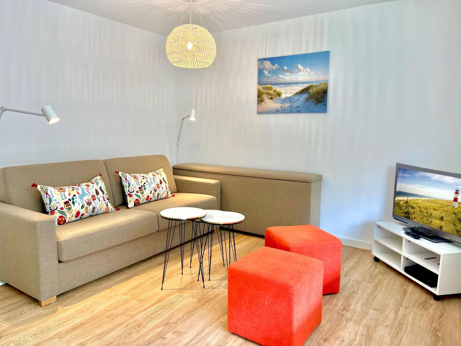 Gemütliches Wohnzimmer mit Sofa und Fernseher