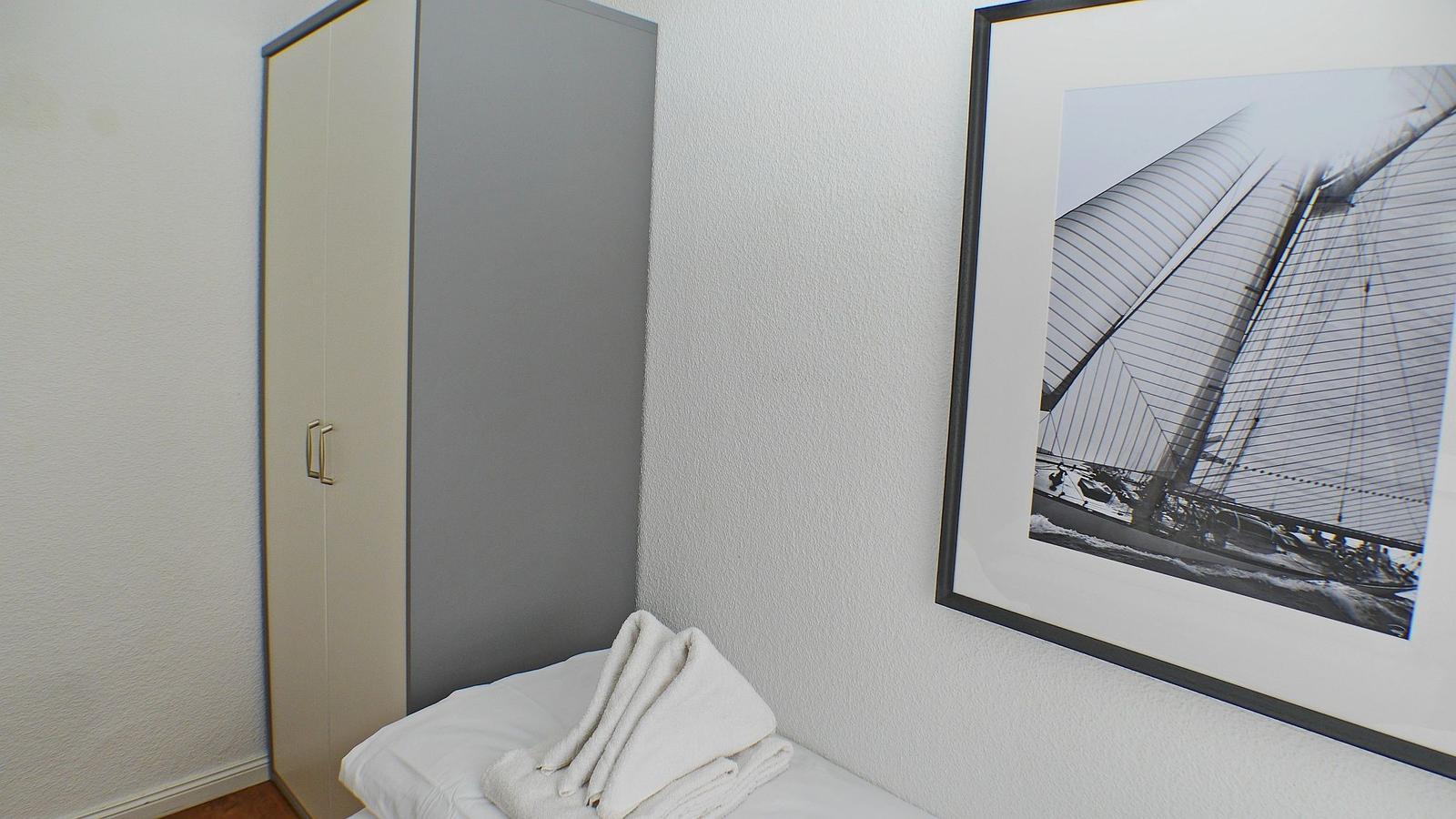 Bedroom with wardrobe and picture on the wall.