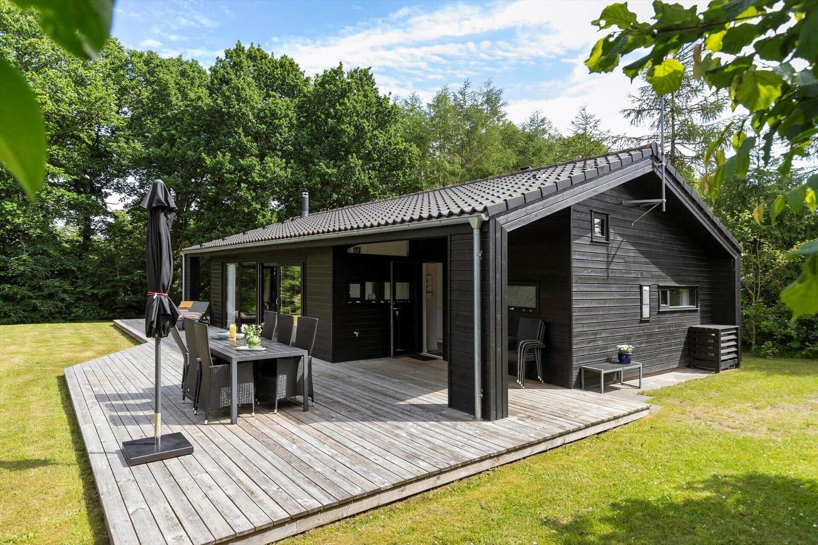 Schwarzes Holzhaus mit Terrasse, Garten und Grillplatz. Moderne Einrichtung und viel Platz.