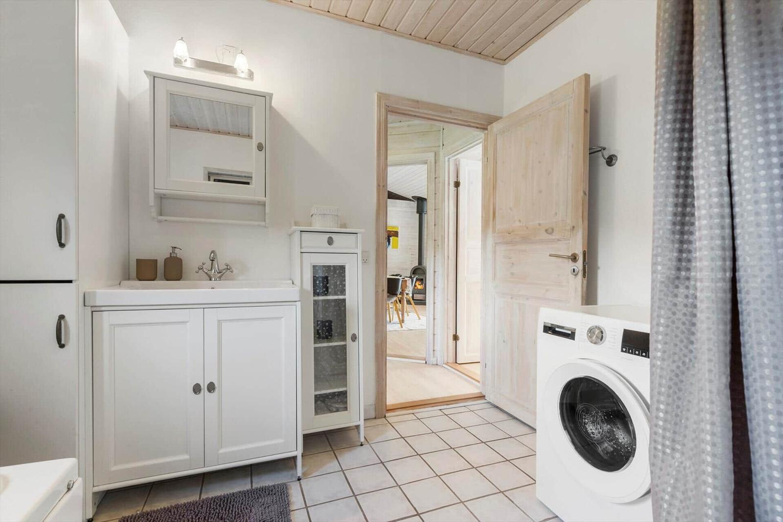 Badezimmer mit Waschmaschine und Blick in Wohnbereich