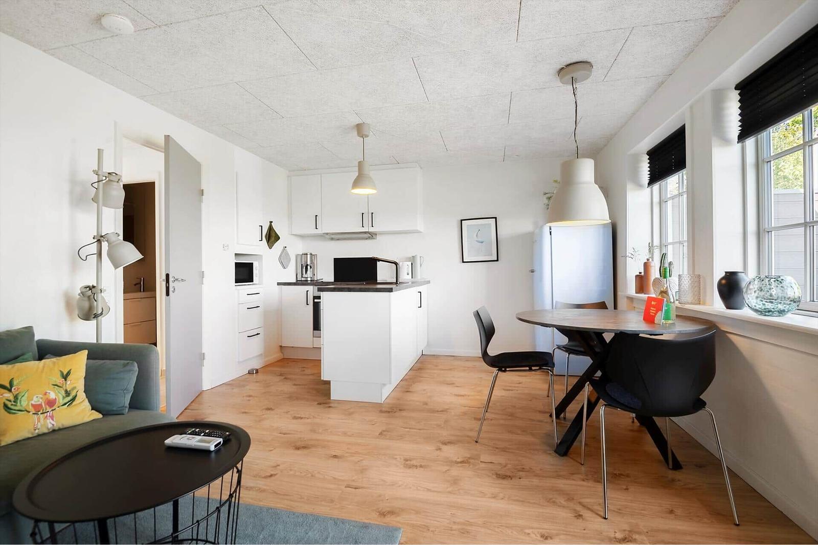 Wohnküche mit Essbereich, Holzboden und Fenster mit Blick.