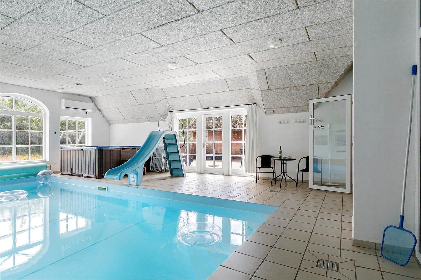 Innenpool mit Rutsche und Sauna. Terrassentür und Sitzgelegenheit vorhanden.