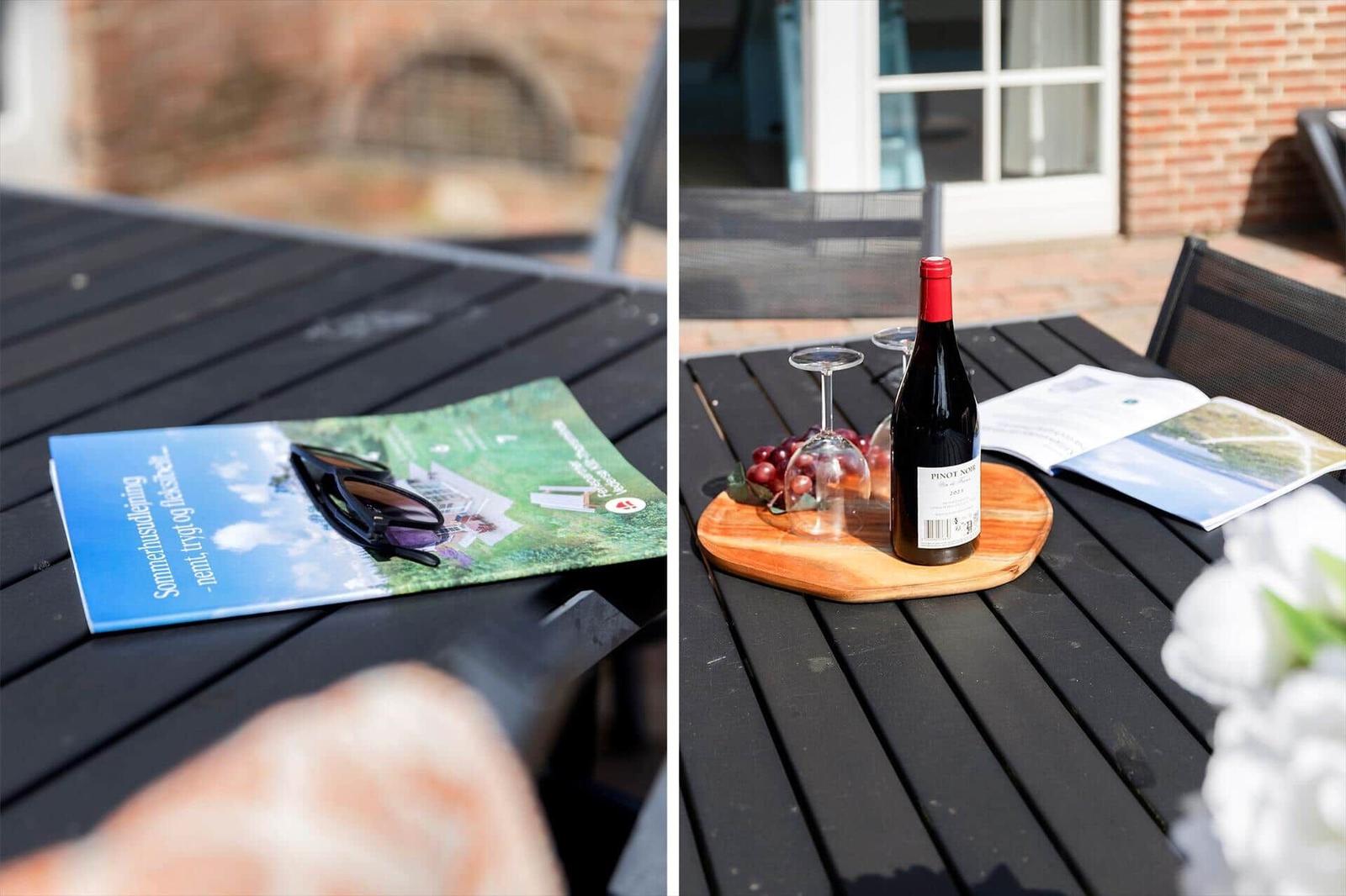 Auf der Terrasse steht ein Tisch mit Wein, Gläsern und Broschüren.