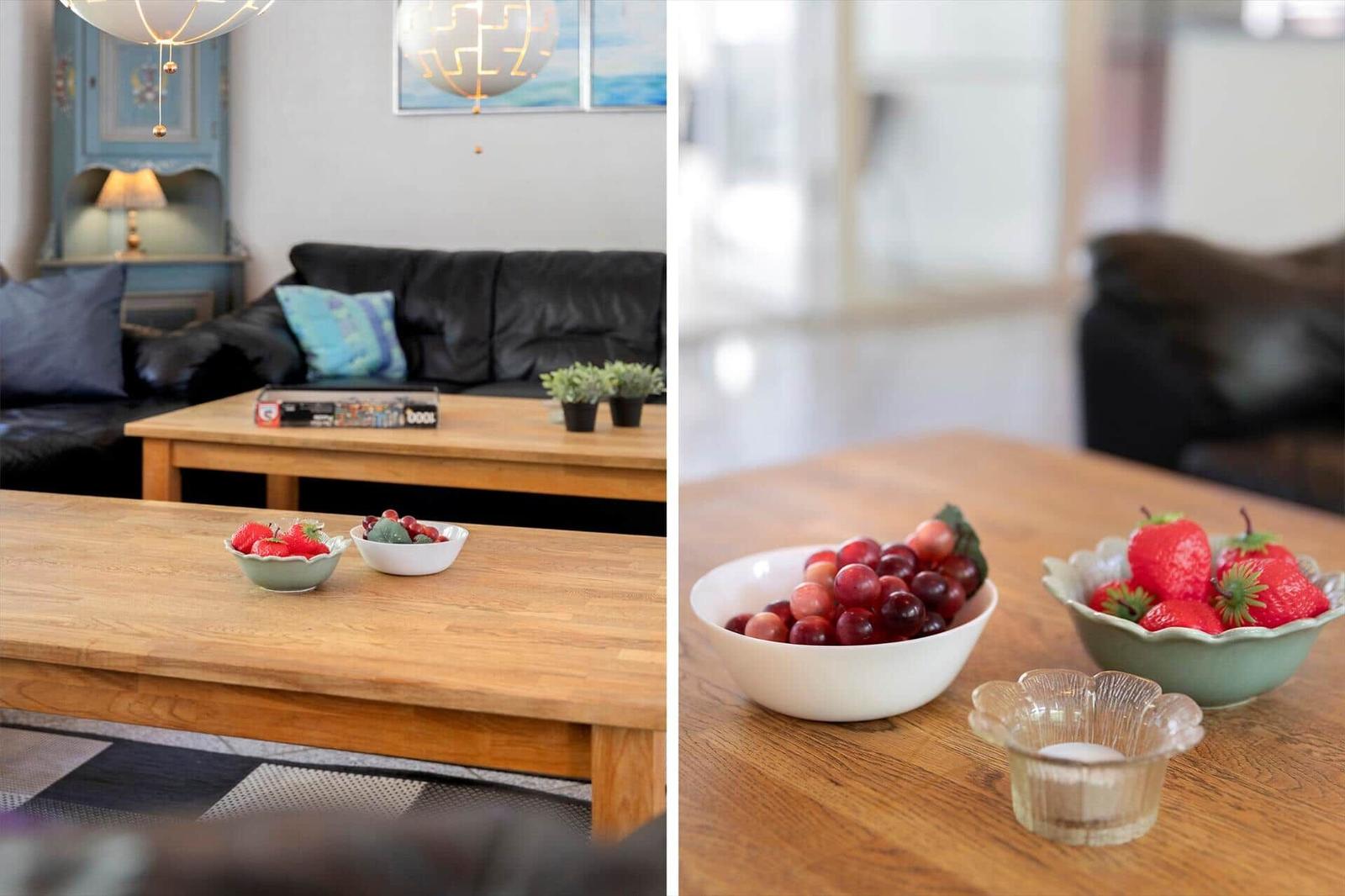 Holztisch mit Obstschalen und Pflanzen im Wohnzimmer.