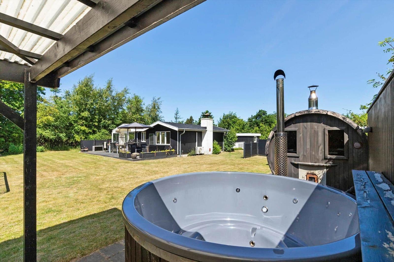 Außenbereich mit Whirlpool, Sauna und Gartenansicht