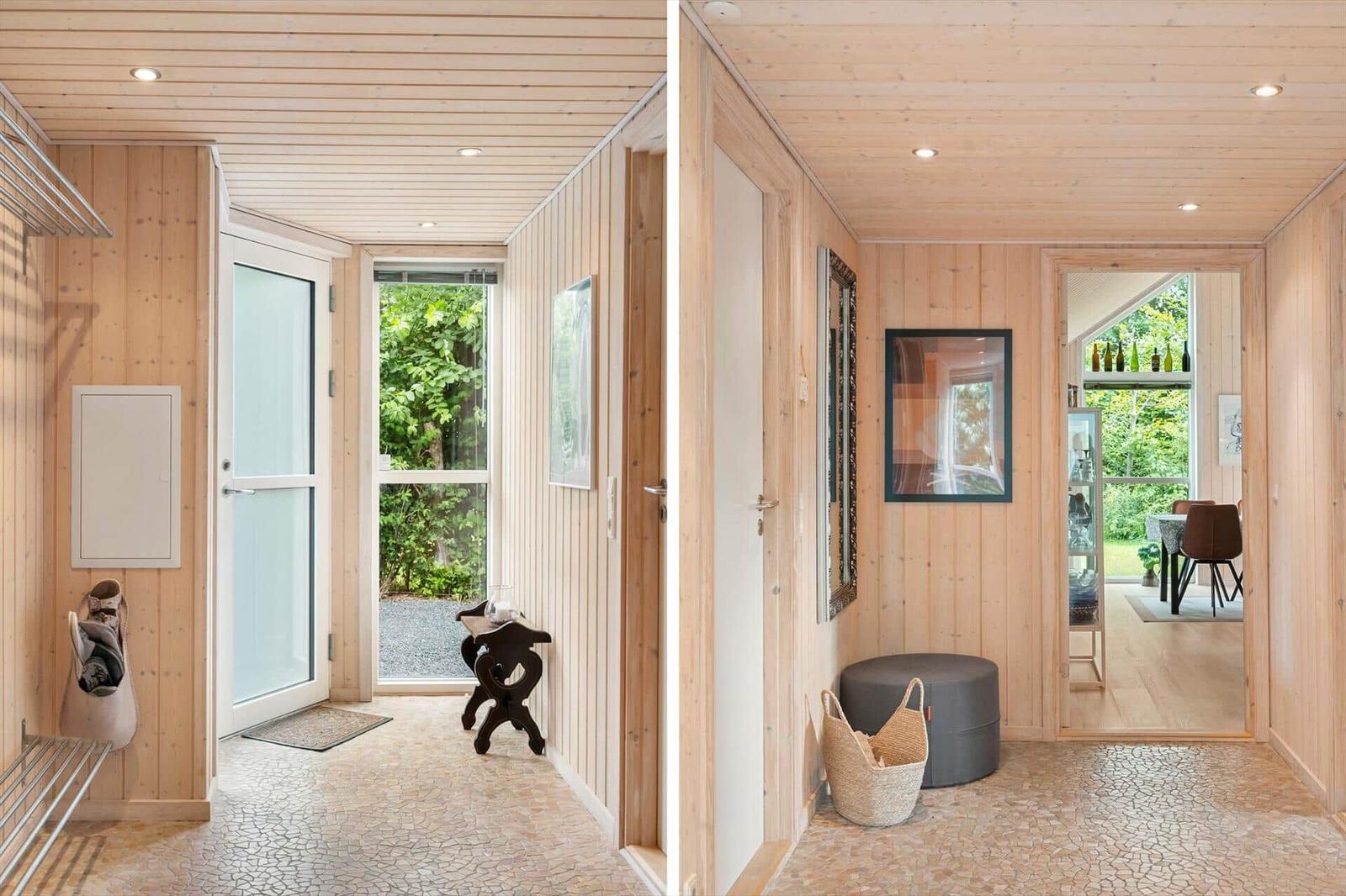 Haus mit Holzwand und Terrasse. Blick ins Esszimmer mit Tisch und Stühlen.
