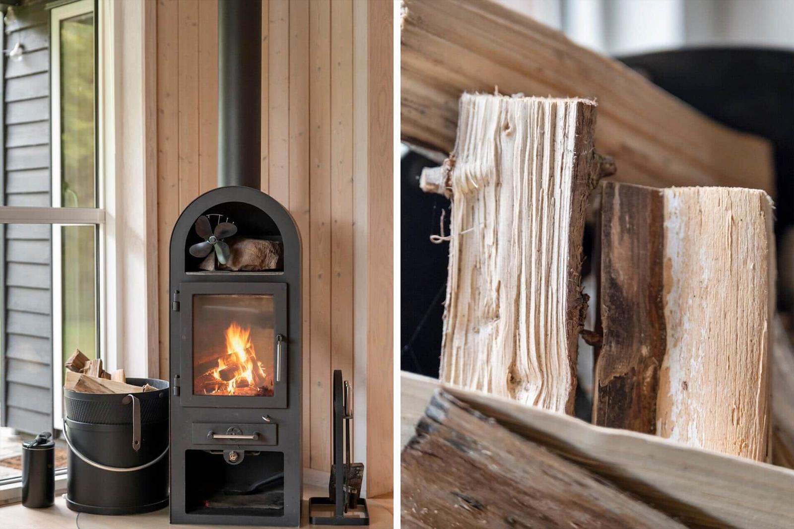 Kaminofen mit brennendem Holz und Stapel Brennholz in rustikaler Umgebung.