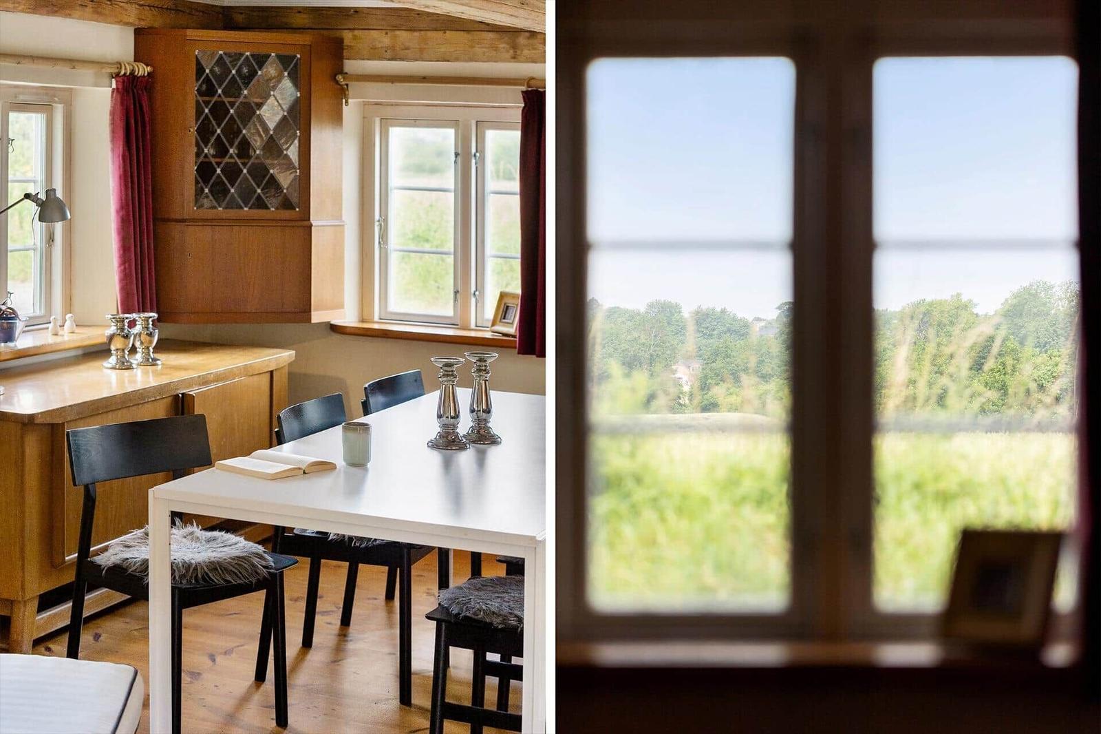 Esszimmer mit Tisch, Stühlen und Blick auf grüne Landschaft.