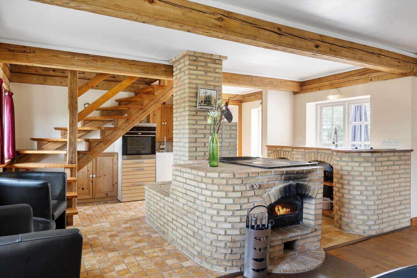 Raum mit Holzstufen, Backofen und Kaminofen aus Ziegelsteinen.