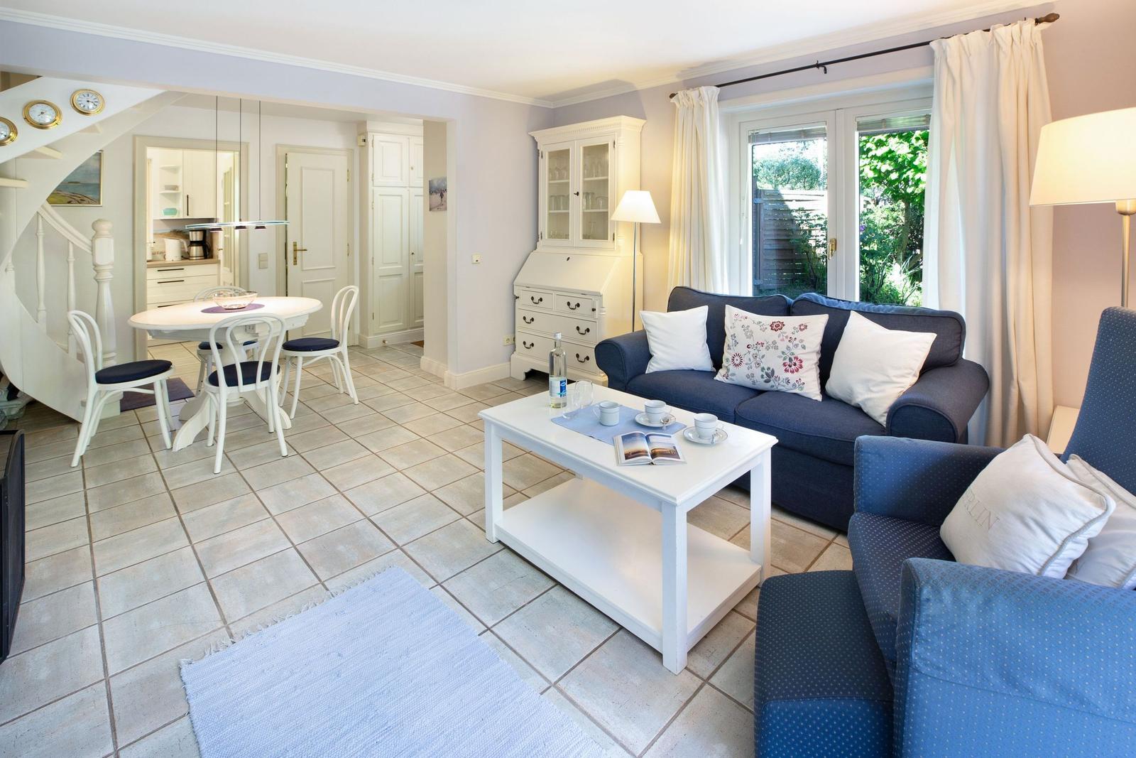 Living and dining area with sofa, table, and garden view