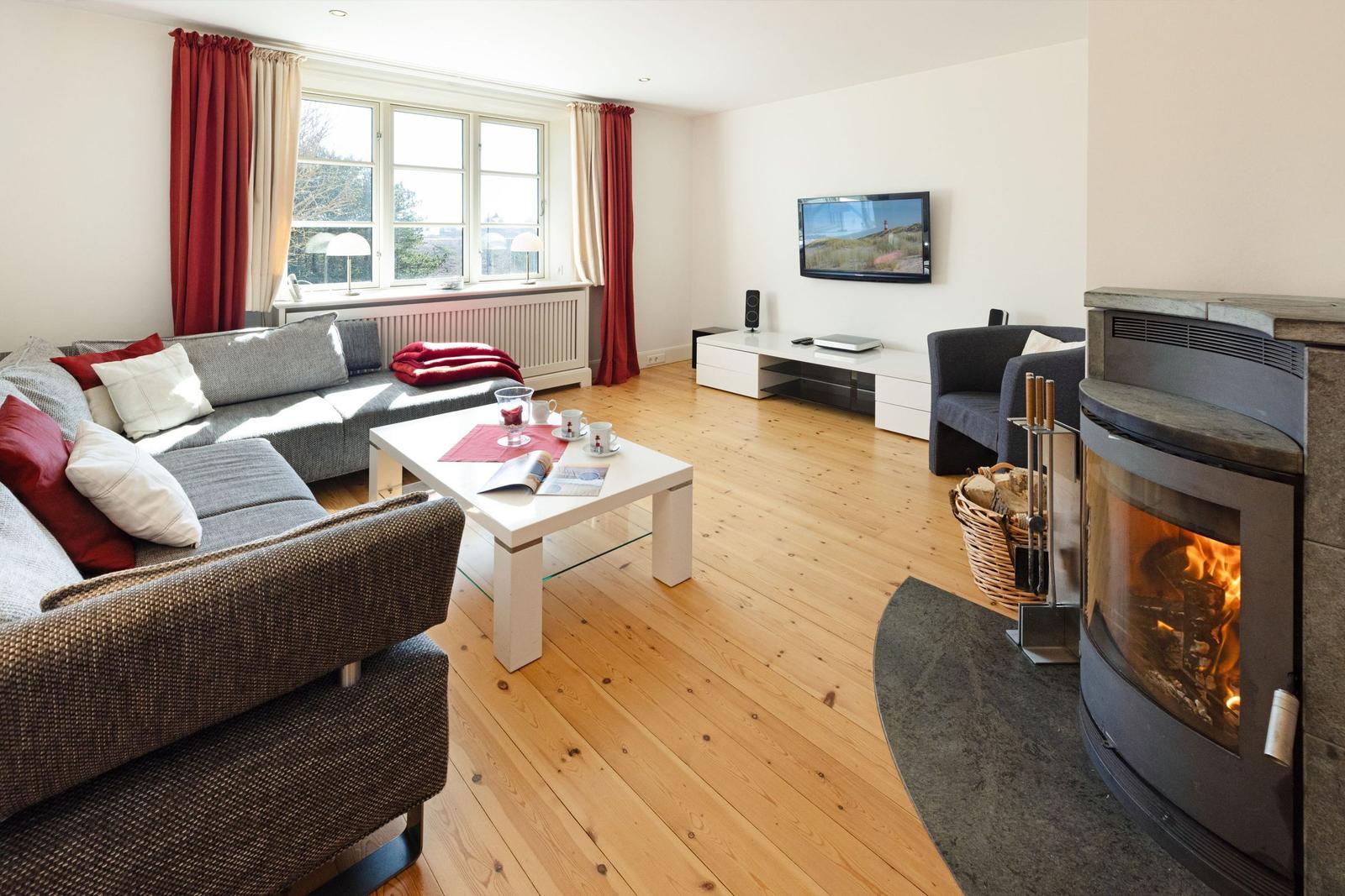 Wohnzimmer mit Sofa, Kamin und Fernseher an der Wand.