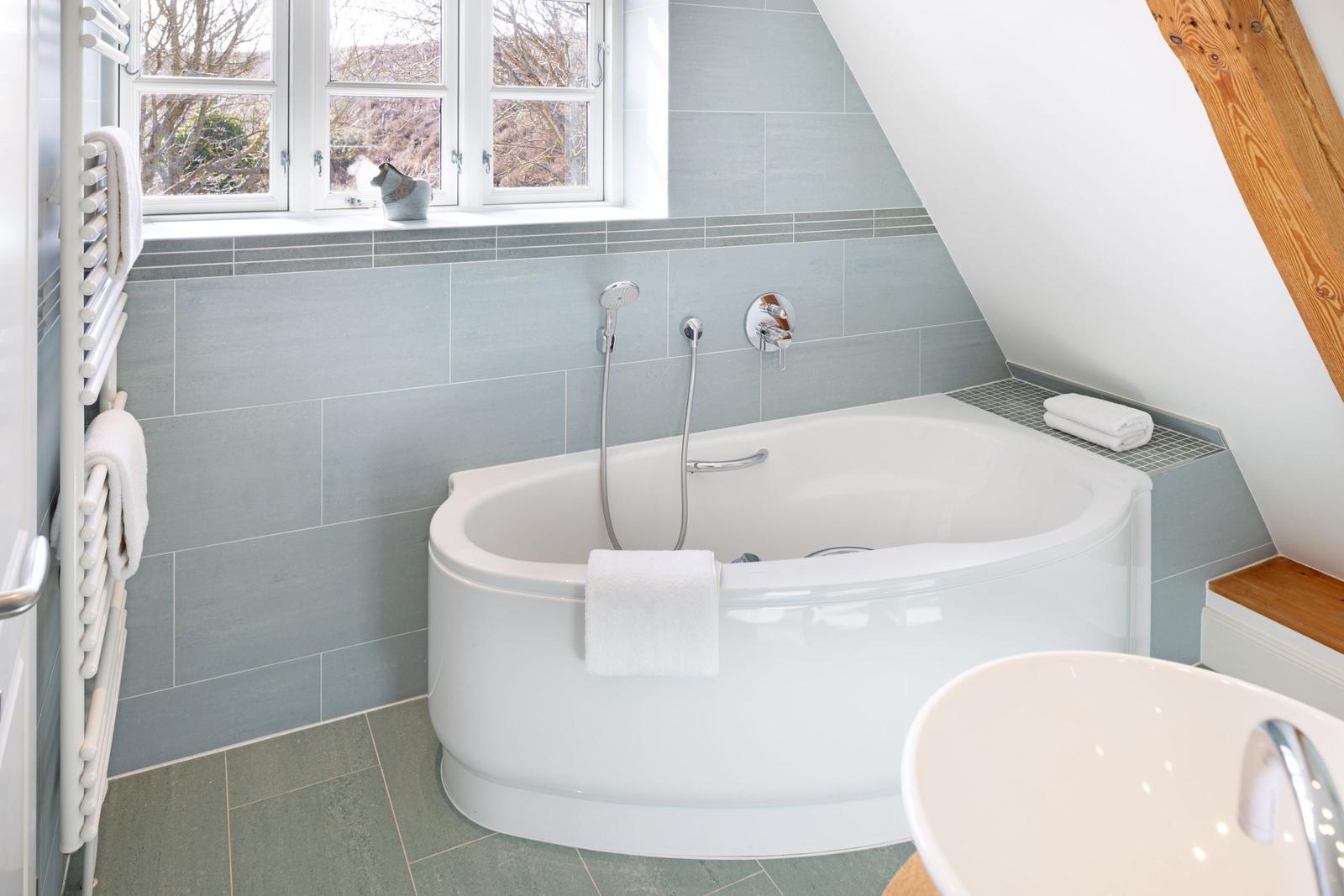 Bad mit Badewanne, Duschbrause und Fenster mit Blick.