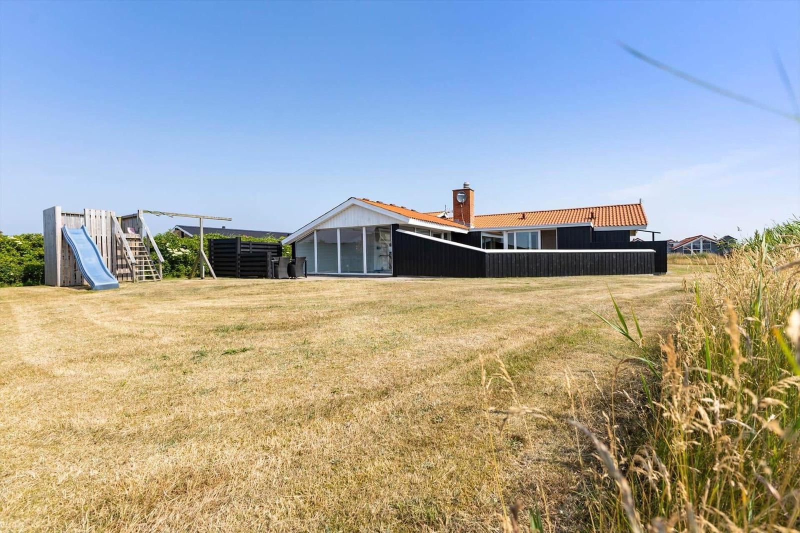 Moderne Villa mit großem Garten und Kinderspielplatz. Terrasse mit Sitzgelegenheiten.