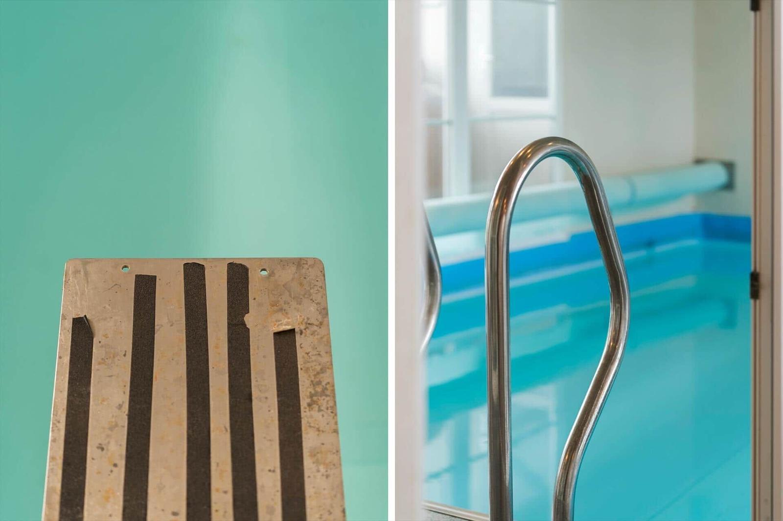 Metalltreppe mit Griff und Schwimmbad im Hintergrund