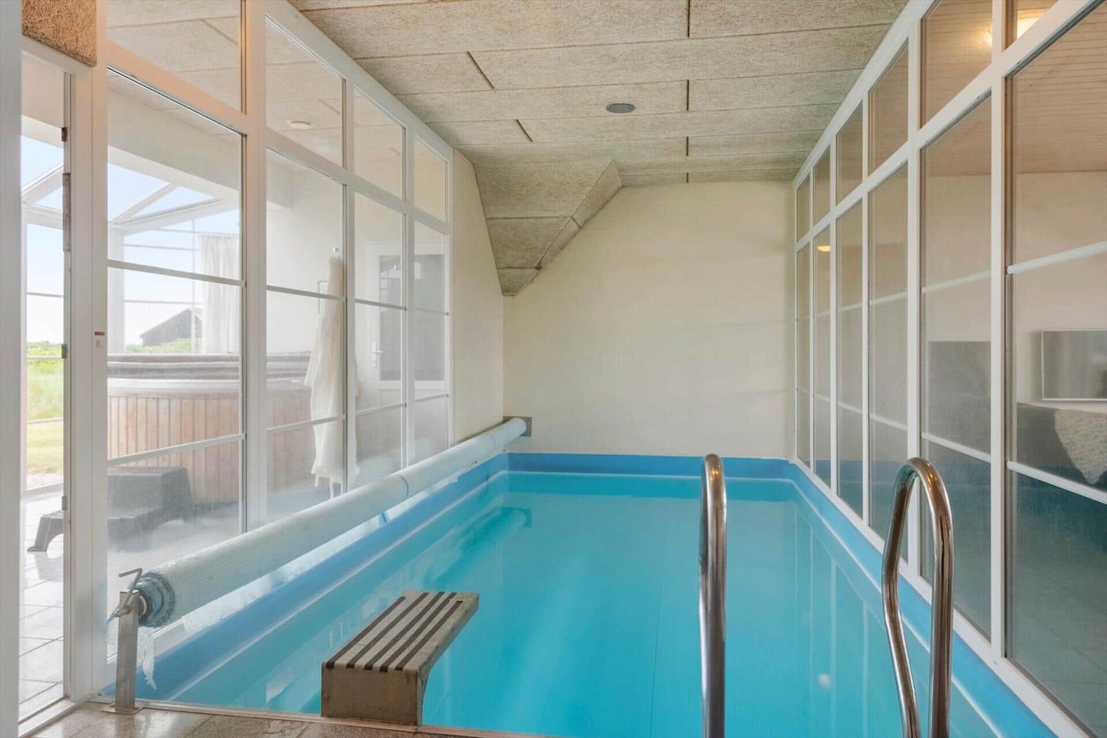 Innenpool mit Glaswänden und Außenterrasse