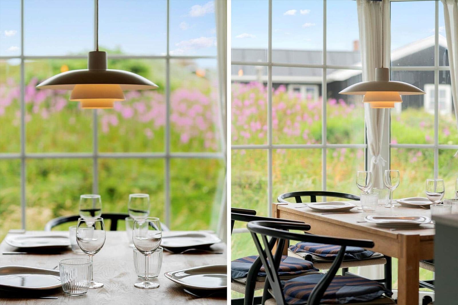Esszimmer mit Tisch, Stühlen und Blick auf Blumenfelder.