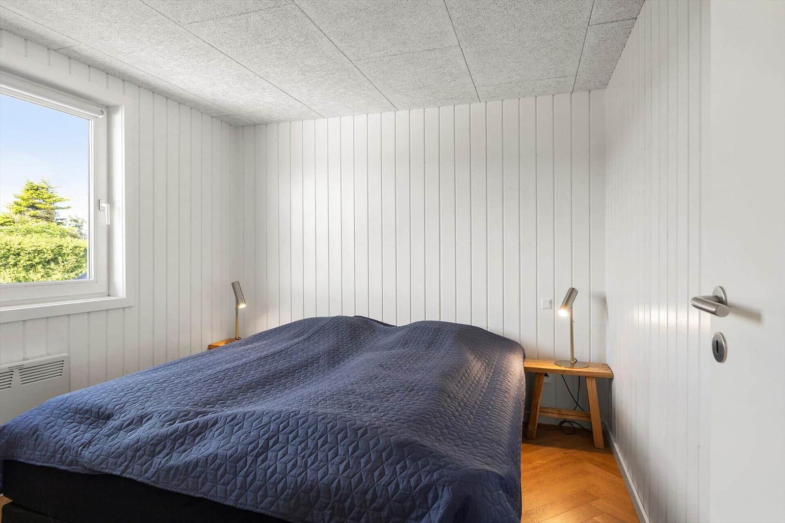 Schlafzimmer mit Bett, Fenster und Nachttischen