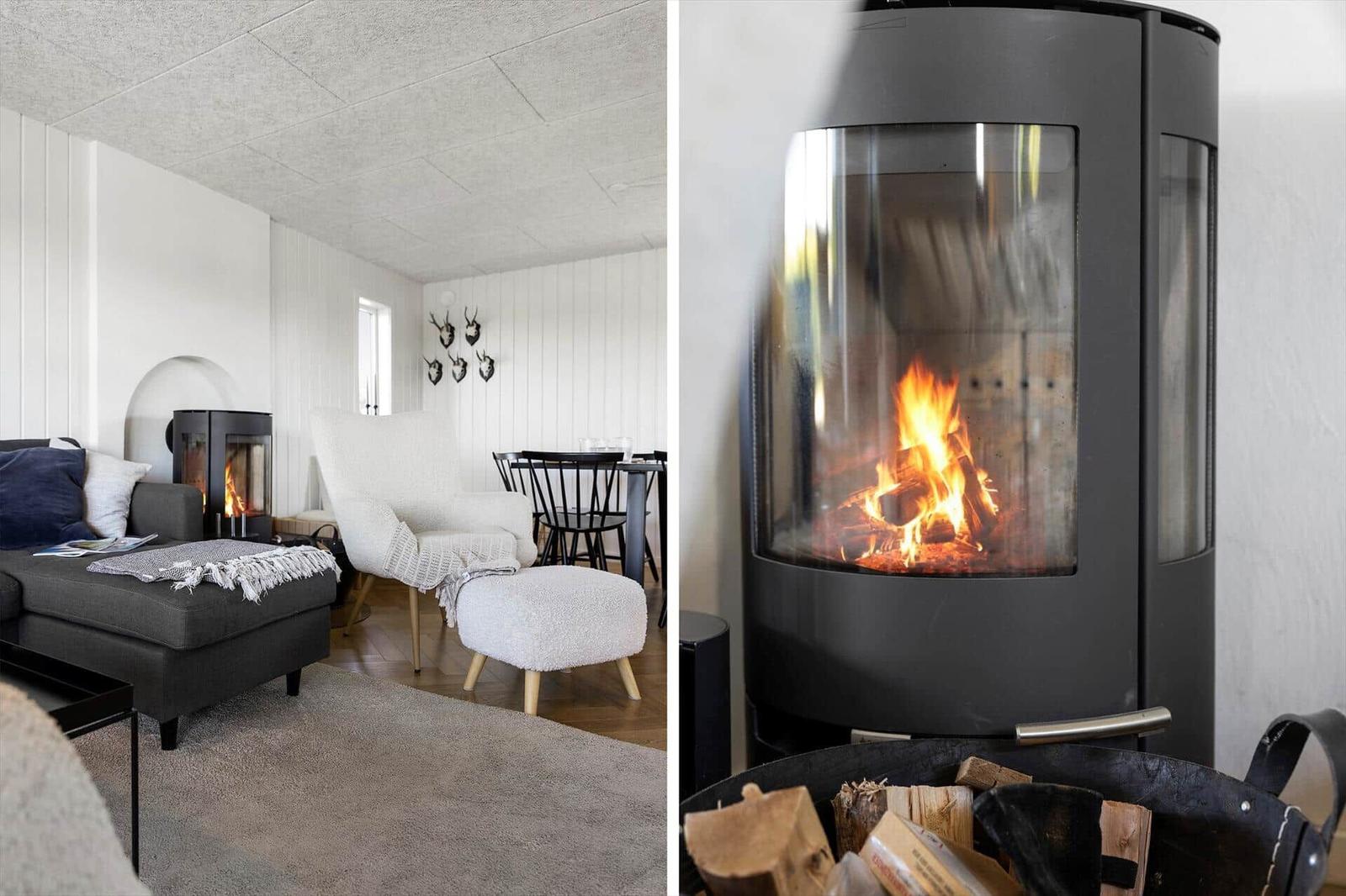 Wohnzimmer mit Kaminofen, Sofa, Sessel und Esstisch. Brennholz im Kaminofen.
