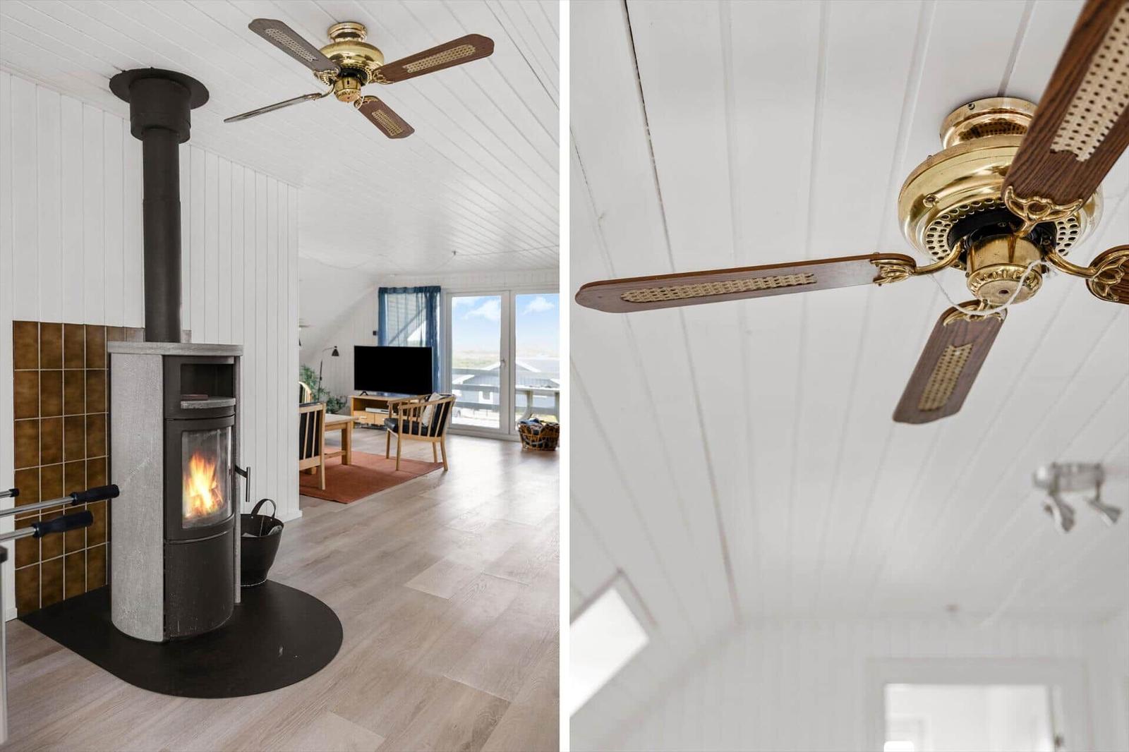 Room with fireplace and ceiling fan, wooden floor and white walls.