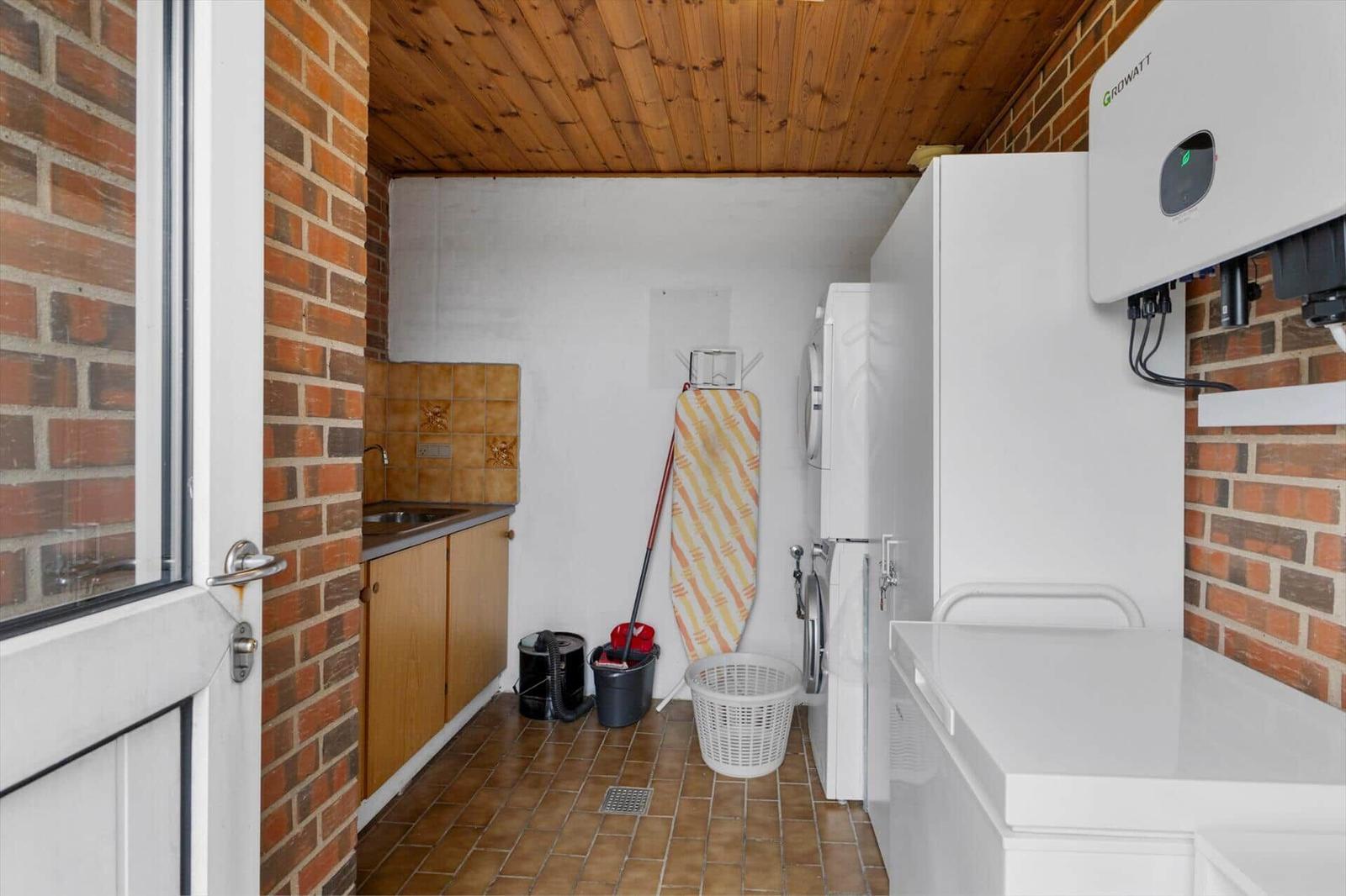 Apartment with washing machine, sink, and heater on the wall