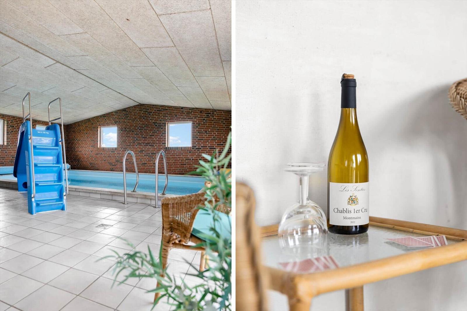 Indoor pool with blue slide and wicker seating. Wine decanter and bottle on table.