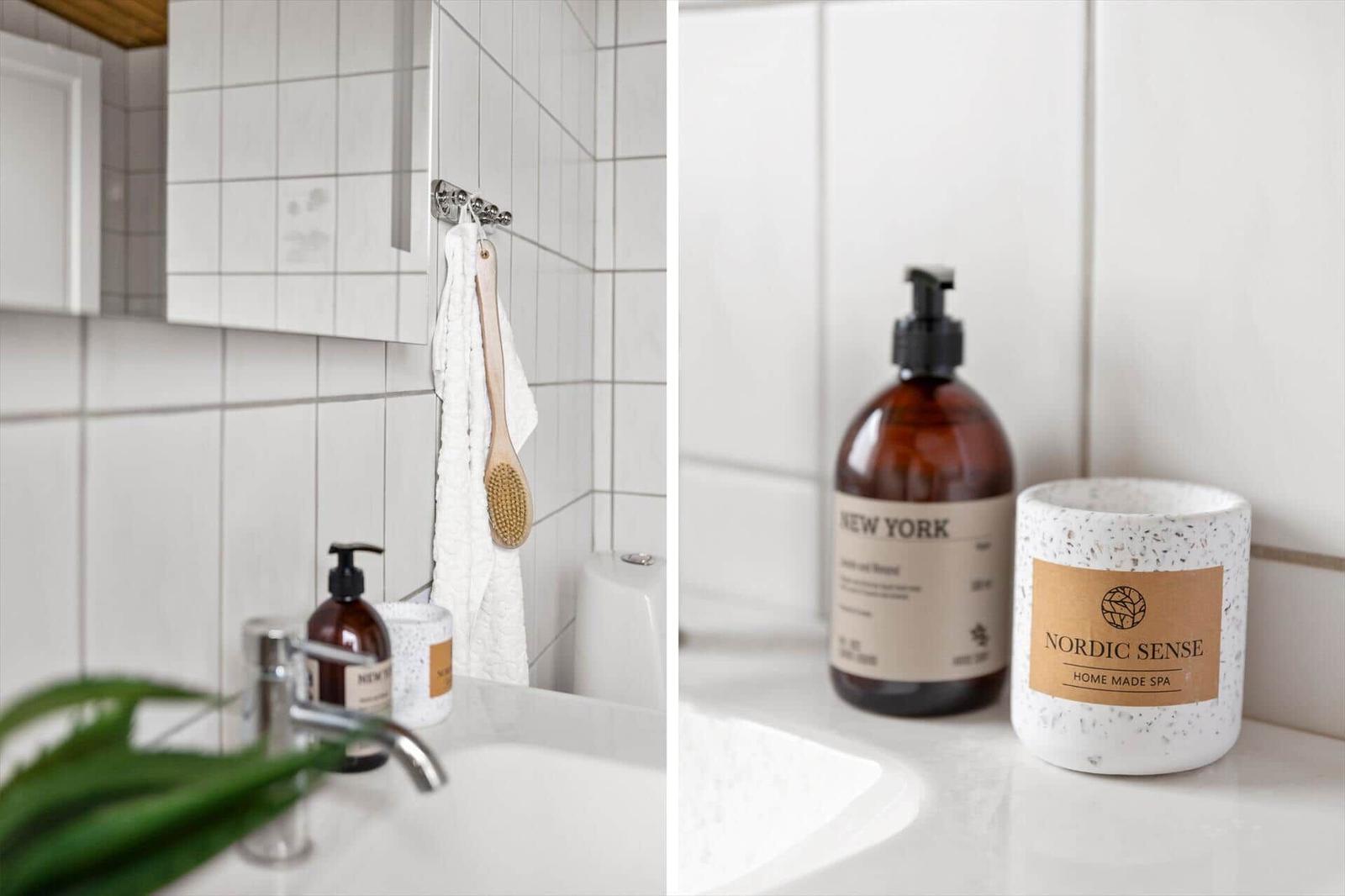 Bathroom with white tiles, sink, and care products.
