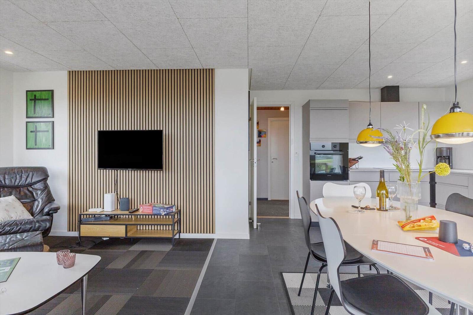 Wohn- und Essbereich mit Küchenzeile und TV-Wand. Moderne Einrichtung.