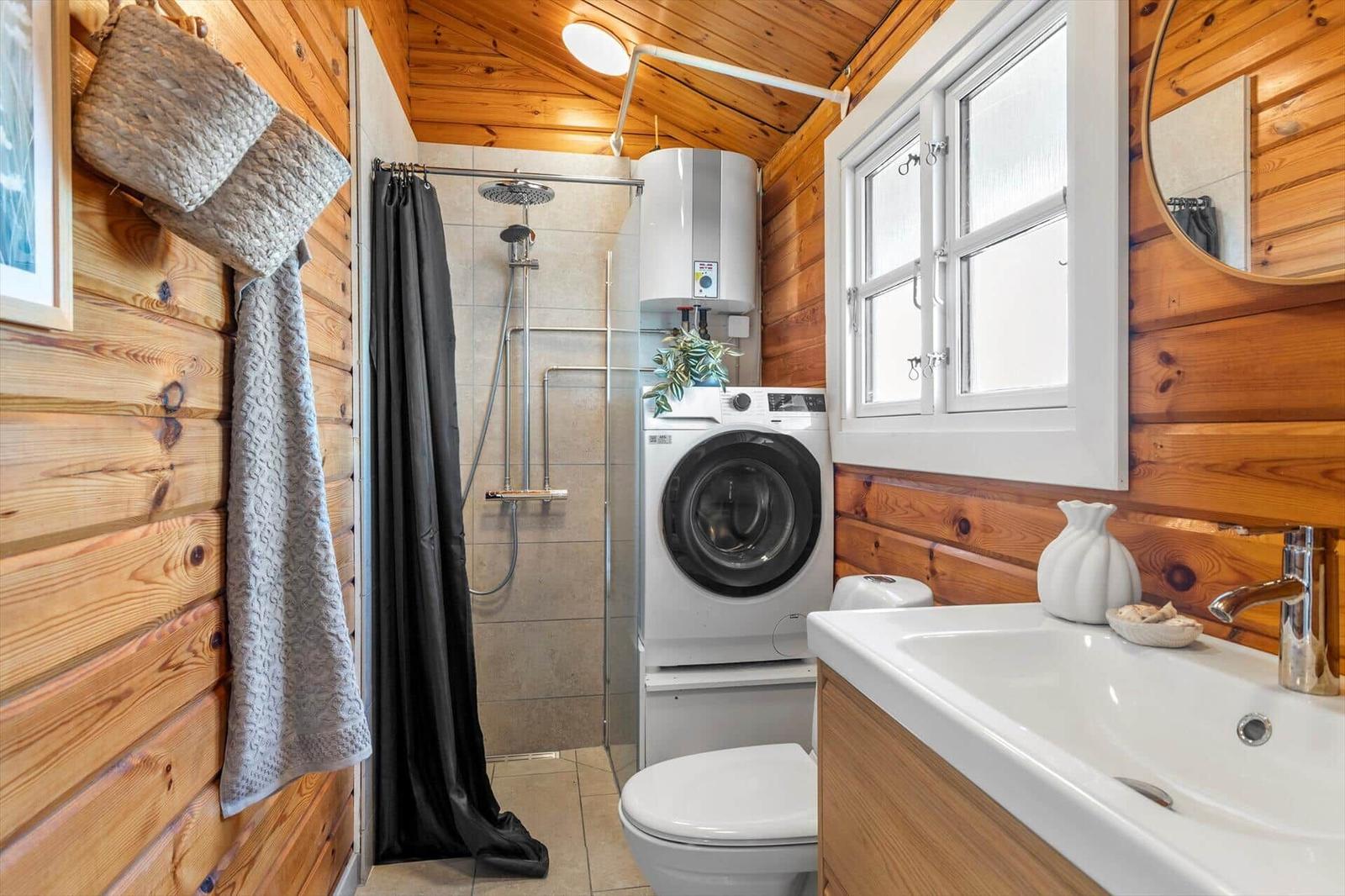 Badezimmer mit Dusche, Waschmaschine und Waschtisch