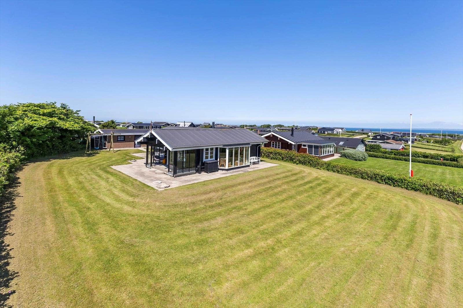 Modernes Haus mit großem Garten und Blick aufs Meer.